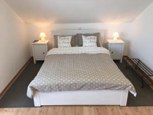 拉科维察VIP Apartments & Room的一间卧室配有一张带2个床头柜的大型白色床