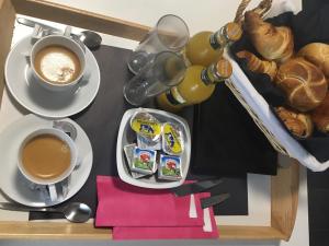 列日Hôtel Verone - Liège Centre的一张桌子,上面放着两杯咖啡和一盘食物