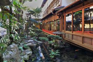 京都宿屋枳壳庄酒店的一条穿越带瀑布的花园的火车