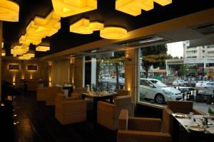 艾哈迈达巴德埃尔多拉多酒店的餐厅设有桌椅,窗户上设有汽车