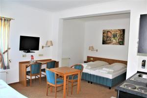 亨施泰特-乌尔茨堡Apartment Hotel的酒店客房带一张床、一张桌子和椅子
