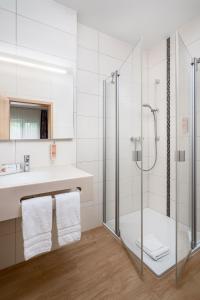 GensingenClassicX Landhaus & Hotel - Bed & Breakfast的一间带玻璃淋浴和水槽的浴室