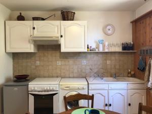Toulon-sur-Arrouxappartement Saint-Antoine的厨房配有白色橱柜、炉灶和水槽。