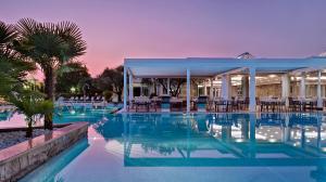 阿巴诺泰尔梅Tritone LUXURY HOTEL THERMAE & SPA的度假村内带桌椅的游泳池