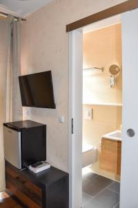 柏林Boutique Hotel Sena的一间带卫生间的浴室和墙上的电视