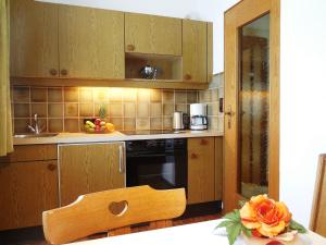 瓦尔赫湖Haus Kurz Matthäus的厨房配有木制橱柜和花桌