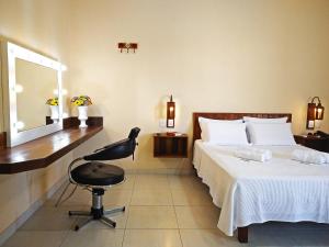 Resende CostaArraial da Lage Hospedaria的一间卧室配有一张床、一把椅子和镜子