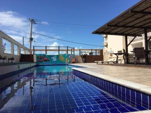 塞古罗港Eden Praia Hotel的游泳池铺有蓝色瓷砖地板。