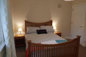 沃特福德Faithlegg House Hotel Holiday Lodge的一间卧室配有一张带两盏灯的木床。