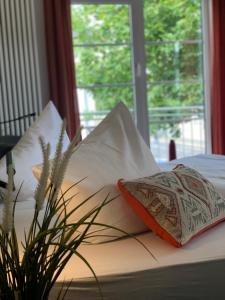 吉森吉森莱西登斯酒店的床上有枕头和植物
