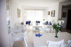 帕尔马海滩伊莎贝尔度假屋的客厅配有白色家具和花瓶