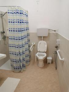 库斯托纳奇Cuore di Conchiglia的一间带卫生间和淋浴帘的浴室
