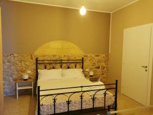 库斯托纳奇Cuore di Conchiglia的一间卧室设有一张床和石墙