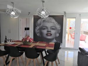 贝尼多姆CASA MARCOS的一间用餐室,里面装饰着一幅女子大画