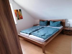 丁克拉格Apartment Grieshop的一间卧室配有一张带蓝色毯子和枕头的床。