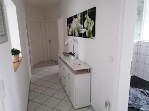 丁克拉格Apartment Grieshop的白色的浴室设有橱柜,墙上挂着一幅画