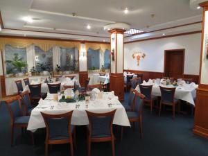 霍夫盖斯马尔祖姆滕坊酒店的一间设有白色桌椅的用餐室