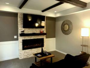 桑达斯基Cedar Stables Inn & Suites的客厅设有壁炉和平面电视