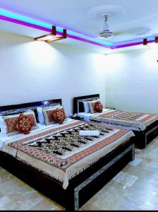 卡拉奇Gulshan Palace Near Millennium Mall的两张床铺位于带灯的房间