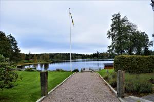 TorupTorups Gästgivaregård的湖前的步行道,带旗帜