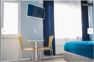 伊斯坦布尔Blue Apartments的一间卧室配有桌子和两把椅子以及一台电视机