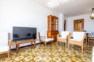 卡拉米洛Skyline Cala Nau的客厅配有平面电视和椅子
