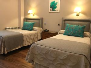 门多萨克丽珑门多萨酒店的配有绿色枕头的酒店客房内的两张床