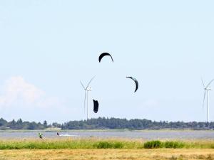 托斯明德7 person holiday home in Ulfborg的两人在风力涡轮机场上放风筝