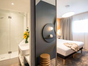 佩尔蒂ibis Styles Pertuis Portes du Luberon的浴室设有床、水槽和镜子