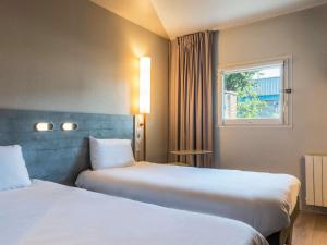 桑利斯桑利斯宜必思快捷酒店的酒店客房设有两张床和窗户。
