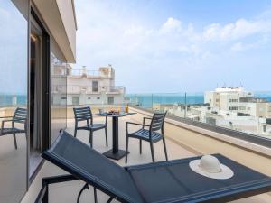 海若克利欧伊拉克利翁中心宜必思尚品酒店的阳台配有桌椅,享有海景。