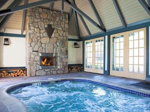 箭头湖UCLA Lake Arrowhead Lodge的一座房子内带石头壁炉的游泳池