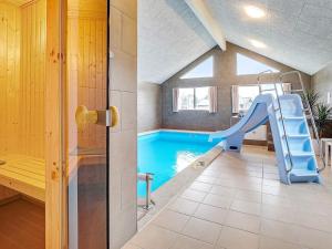 格雷诺20 person holiday home in Grenaa的一个带滑梯的游泳池,位于带房子的房间
