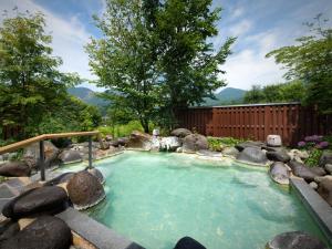 藏王温泉昭四季酒店的一个带岩石的花园内的热水浴池