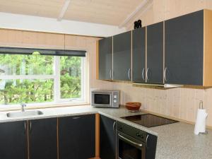 奥克斯伯尔Three-Bedroom Holiday home in Oksbøl 17的厨房配有水槽和微波炉