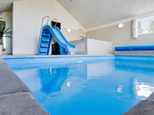 格莱斯堡14 person holiday home in Glesborg的一个带蓝色滑梯的大型游泳池