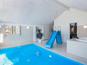 格莱斯堡14 person holiday home in Glesborg的一个带滑梯和蓝色滑梯的室内游泳池