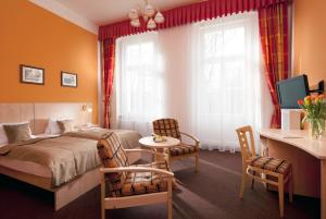 弗兰季谢克矿泉镇梅特罗普尔酒店的酒店客房带一张床、一张桌子和椅子