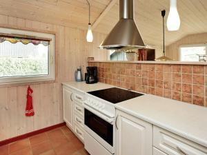 海默特6 person holiday home in Hemmet的厨房配有白色橱柜和炉灶烤箱。