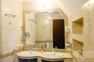 考波什堡Hotel Dorottya的一间带两个盥洗盆和大镜子的浴室