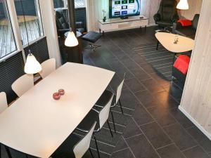 乌尔夫堡6 person holiday home in Ulfborg的一间设有桌椅和电视的会议室