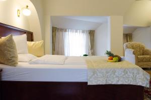 考波什堡Hotel Dorottya的一间卧室,配有一张床,上面放着一碗水果