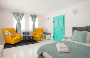 瓦马Hygge Hut的卧室配有黄色和蓝色的椅子和1张床