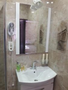 曼哲罗克曼泽洛公园酒店的浴室配有盥洗盆和带镜子的淋浴