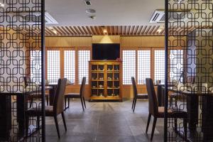 釜山附上将军酒店的一间带桌椅和电视的用餐室