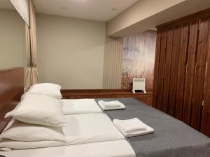 彼得罗扎沃茨克Harland apartments的卧室配有一张带白色床单和枕头的大床。