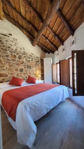 阿维拉Casas del Castillo, 3的卧室配有一张石墙内的大床