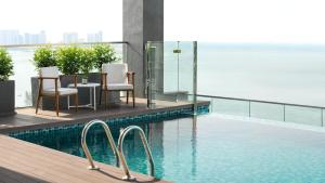 乔治市槟城遨舍乔治市酒店的一个带椅子的游泳池,享有水景