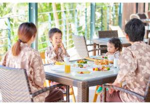 本部冲绳马海纳健康度假酒店的一群坐在餐桌上吃食物的人