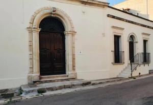LizzanelloIl Giardino Segreto的白色建筑一侧的黑色门